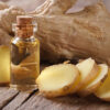 oil of ginger in a small glass bottle macro and root on the table, horizontal